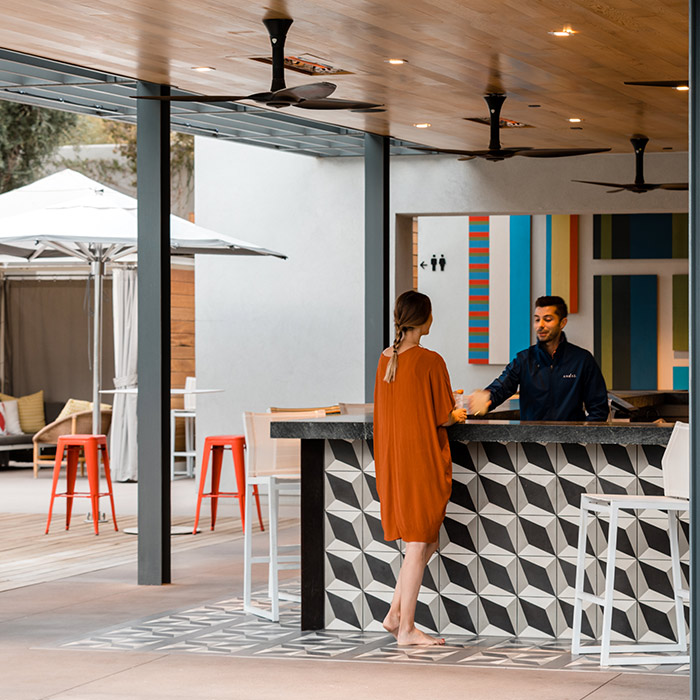 A guest ordering a drink at the bar and talking with friendly and attentive hotel staff