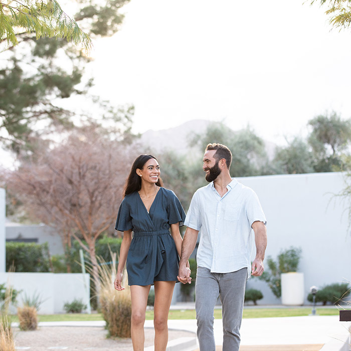 A couple holding hands and walking in a hotel resort